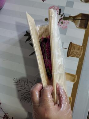 抓起寿司帘两端，往中间挤压一下！