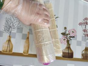 手扶住食材，双手虎口夹住卷帘，使劲儿往下按下一下！边卷边按压直到把寿司海苔卷完！