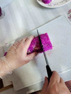 手轻轻的扶住寿司，用锋利一点儿的刀，上下滑动切开寿司，如果粘刀，就把刀用水冲一下再切！