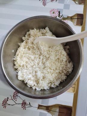 东北大米500克淘洗干净，倒入电饭锅里，放入600克水，1克盐，2克食用油搅拌均匀，按煮饭键！饭蒸熟后，焖5分钟，倒入容器中，放入适量的寿司醋（1小盖儿就可以了！没有也可以不放！），适量的熟白芝麻，香油搅拌均匀，晾至温热备用！