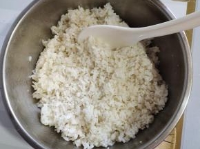 东北大米500克淘洗干净，倒入电饭锅里，放入600克水，1克盐，2克食用油搅拌均匀，按煮饭键！饭蒸熟后，焖5分钟，倒入容器中，放入适量的寿司醋（1小盖儿就可以了！没有也可以不放！），适量的熟白芝麻，香油搅拌均匀，晾至温热备用！