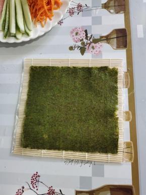取一张寿司海苔放在寿司帘上！粗糙的那一面朝上！
