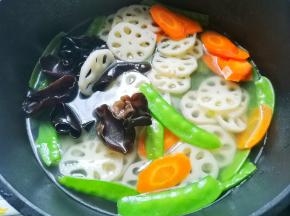 锅中烧开水，水开后将藕片、 胡萝卜放入煮1分钟后捞出过凉，之后将木耳、荷兰豆放入煮30秒后捞出过凉。