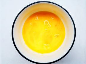 鸡蛋磕入碗中搅散。