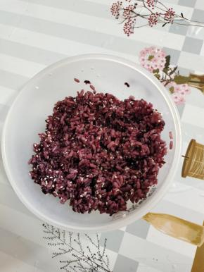 蒸熟的紫米饭打散，放入适量的熟白芝麻，食用油和香油，寿司醋适量搅拌均匀！晾至温热！