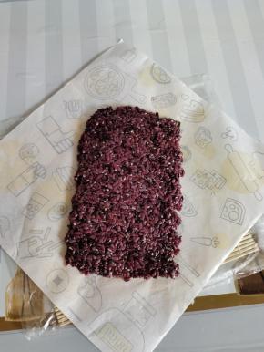 取90克拌好的紫米饭，均匀的平铺在海苔上！（铺米饭的方法以前发帖有写，就不在重复说了！）