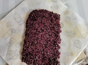 取90克拌好的紫米饭，均匀的平铺在海苔上！（铺米饭的方法以前发帖有写，就不在重复说了！）