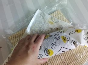 把包装纸的头塞到海苔的下面！然后去给它卷一下！（左手按住，右手往回拉！再往前卷一下，再按一下给它定一下型！！拉的时候要轻轻的，不要用蛮力，会容易碎！）