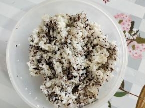 米饭里加入适量的熟白芝麻，食用油和香油，自制海苔碎翻拌均匀！