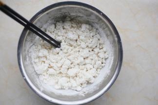 糯米粉放大盆中，边加温水边用筷子搅成絮状，