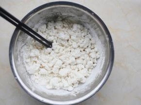 糯米粉放大盆中，边加温水边用筷子搅成絮状，