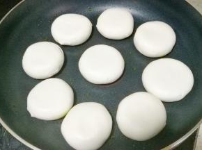 平底锅刷层油，放入糯米饼煎至两面微黄，