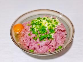 肉糜中加入切好的葱姜碎，磕入鸡蛋。
