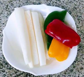 准备原材料白萝卜去皮洗净切成长条青椒、黄椒、红椒去蒂去籽洗净备用