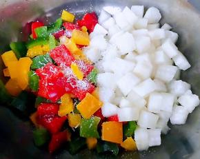 白萝卜和彩椒放入容器中再放入调味料糖、醋、味精少许盐