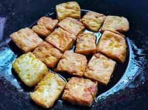 锅中多加点油，下豆腐煎至两面金黄，