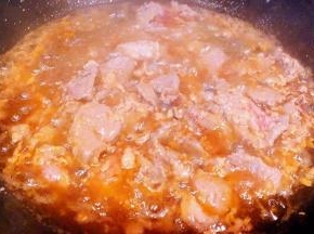 锅中倒入油加热划入煨制入味的羊肉片轻轻翻动炸至羊肉片刚刚变色熟透即可盛出备用