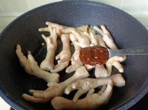 把凤爪翻炒至两面金黄色，加黄豆酱一勺。