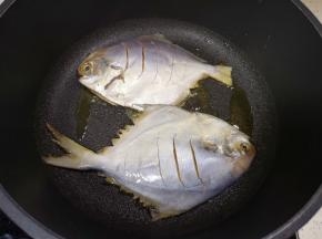 平底锅倒适量的食用油烧热，放入腌制好的鲳鱼。 