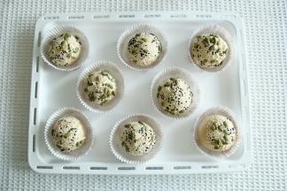 面团表面喷上适量水，滚上一圈装饰材料。喜欢可以滚多一些。放入圆形油淋膜中央。排入烤盘。没有托就摆在烤盘上。