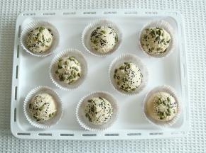 面团表面喷上适量水，滚上一圈装饰材料。喜欢可以滚多一些。放入圆形油淋膜中央。排入烤盘。没有托就摆在烤盘上。