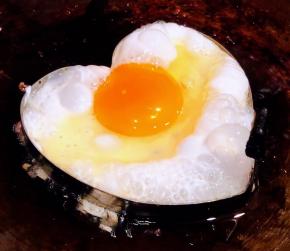 锅中倒入底油加热摆上模具打入鸡蛋中火煎起来