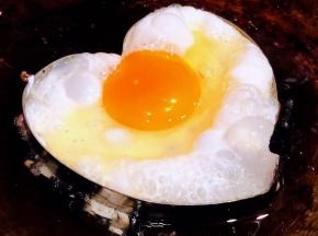 锅中倒入底油加热摆上模具打入鸡蛋中火煎起来