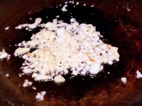 另起锅倒入底油加热放入蒜粒爆香