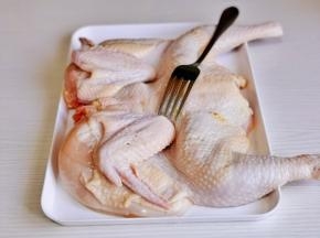 三黄鸡清洗干净，用食品叉 叉出孔便于入味，再用厨房用纸擦干。