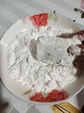 盘子擦干净，倒入适量的淀粉，把腌制好的带鱼放进去，均匀的裹上一层淀粉！