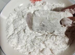 盘子擦干净，倒入适量的淀粉，把腌制好的带鱼放进去，均匀的裹上一层淀粉！