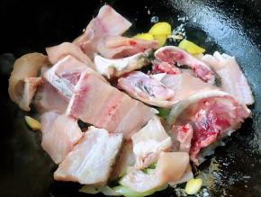 另起锅倒入适量油加热放入葱姜蒜爆香再放入鱼骨大火快速翻炒片好的鱼片清洗干净沥干水份