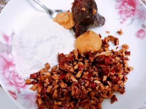 现在做内馅，盘里加入面粉，红枣粒，花生酱和红豆沙