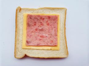 取两片吐司，其中一张上摆1片芝士、叠1片培根，再盖1片吐司。