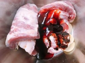 猪颈肉洗净沥干水，加入叉烧酱，老抽，蒜片，料酒