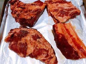 烤盘里铺上锡纸，把腌制入味的猪颈肉摆入烤盘里，我另外多做了一块五花肉。放入预热好的烤箱中层180度烤25分钟左右