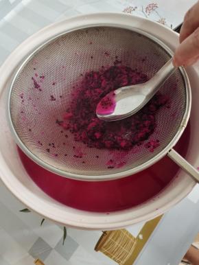 把火龙果放进网筛中，用勺子按压成泥状，再在锅里来回的搅拌，按压！直到火龙果的果肉全部都融进水里，把火龙果籽过滤出来扔掉！