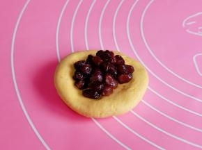 取一块面团揉圆再压扁，加入蜜豆馅，虎口手法包起来。