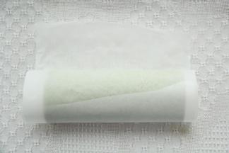 提起油纸，借助擀面杖卷起蛋糕卷，裹好油纸密封冷藏定型。