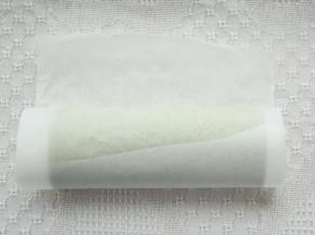 提起油纸，借助擀面杖卷起蛋糕卷，裹好油纸密封冷藏定型。