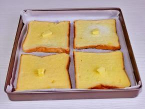 全部裹好放入烤盘中，每片吐司上放2克黄油。