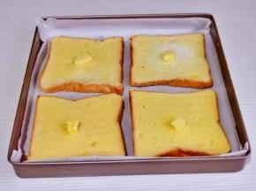 全部裹好放入烤盘中，每片吐司上放2克黄油。