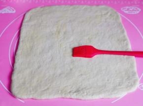 面团擀成正方形大面片，刷上炼乳酱。