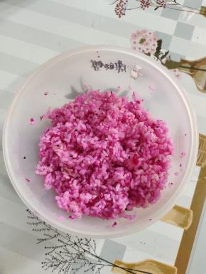 把调拌好的米饭，取三份之二出来，加入几块红心火龙果！火龙果捏成泥状，和米饭一起搅拌均匀，调成红色的米饭！