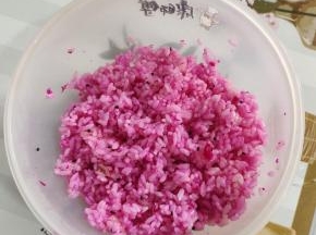 把调拌好的米饭，取三份之二出来，加入几块红心火龙果！火龙果捏成泥状，和米饭一起搅拌均匀，调成红色的米饭！