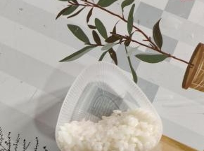 取适量的白色米饭，放在三角饭团模具底部三分之一出，按压紧实一些！