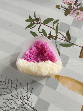 挖几勺红色米饭放在三角饭团模具底部！