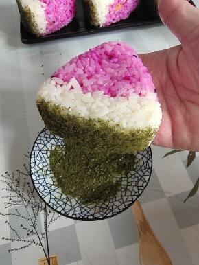 在西瓜饭团底部沾上一些海苔末，做成西瓜皮的样子，装饰一下！