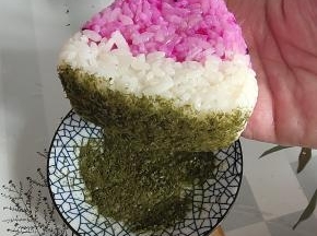 在西瓜饭团底部沾上一些海苔末，做成西瓜皮的样子，装饰一下！
