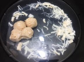 锅里加入适量清水，把泡发好的元贝连同水一起加入，放入牛肉丸煮出鲜味